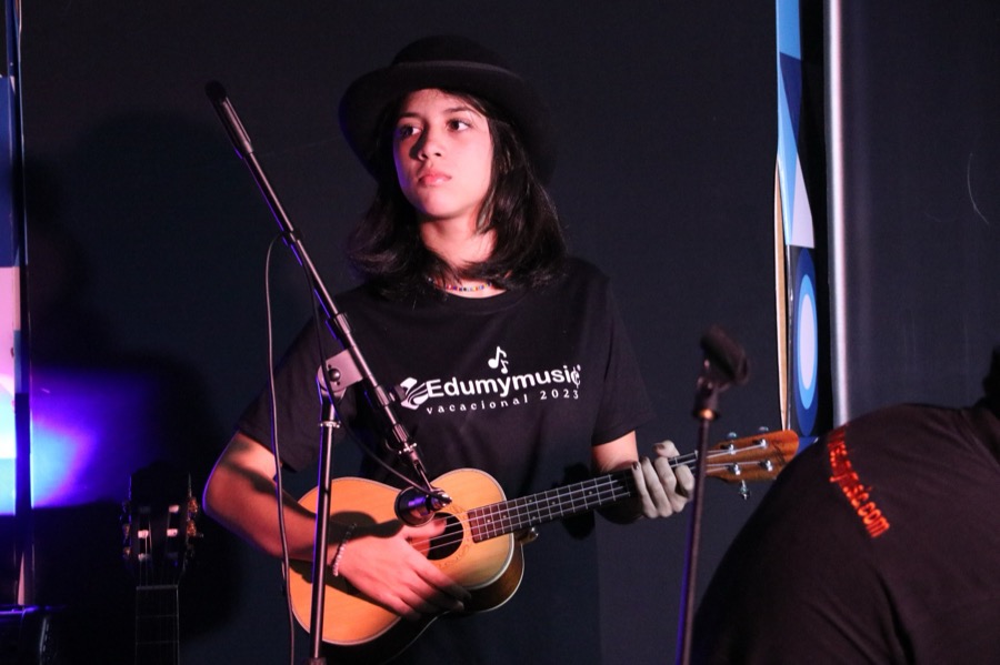 Alumna cantando en escenario con banda